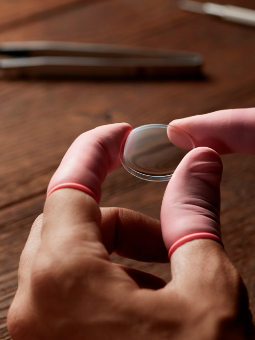 Watch glass in artisan's hand