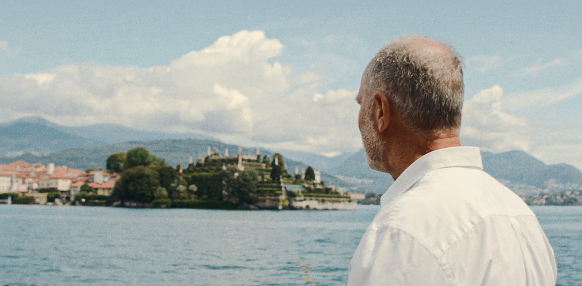 Blue Lake Maggiore in Italy with man facing Lake